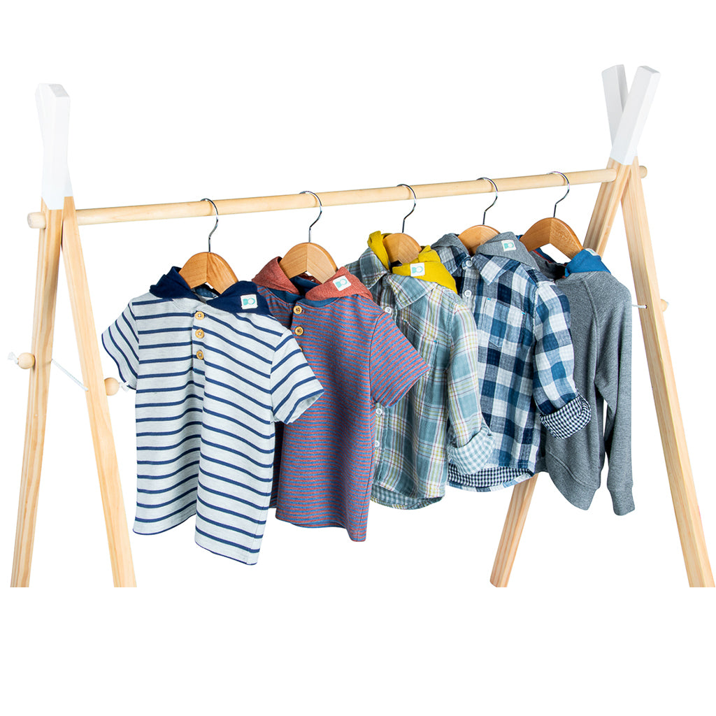 children's shirts in stripe and plaid patterns with dettachable hoods on woodenclothing rack. picture is at a 45 degree angle